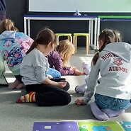 dzieci siedzą na podłodze i kodują