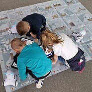 dzieci siedzą na podłodze i kodują