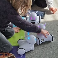 dzieci siedzą na podłodze i kodują