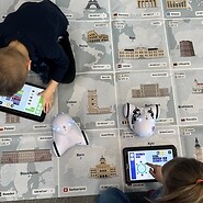 dzieci siedzą na podłodze i kodują