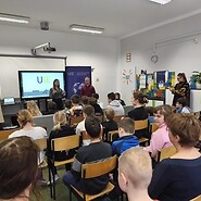 uczniowe siedzą w sali lekcyjnej i słuchają wykładu