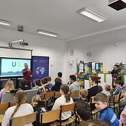 uczniowe siedzą w sali lekcyjnej i słuchają wykładu