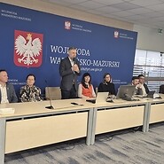 członkowie komisji siedzą przy stole