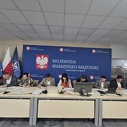 członkowie komisji siedzą przy stole