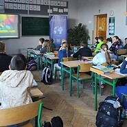 dzieci siedzą przy ławkach w sali lekcyjnej