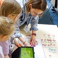 dzieci i prowadząca podczas nauki kodowania