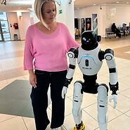 kobieta pozuje do zdjęcia z robotem